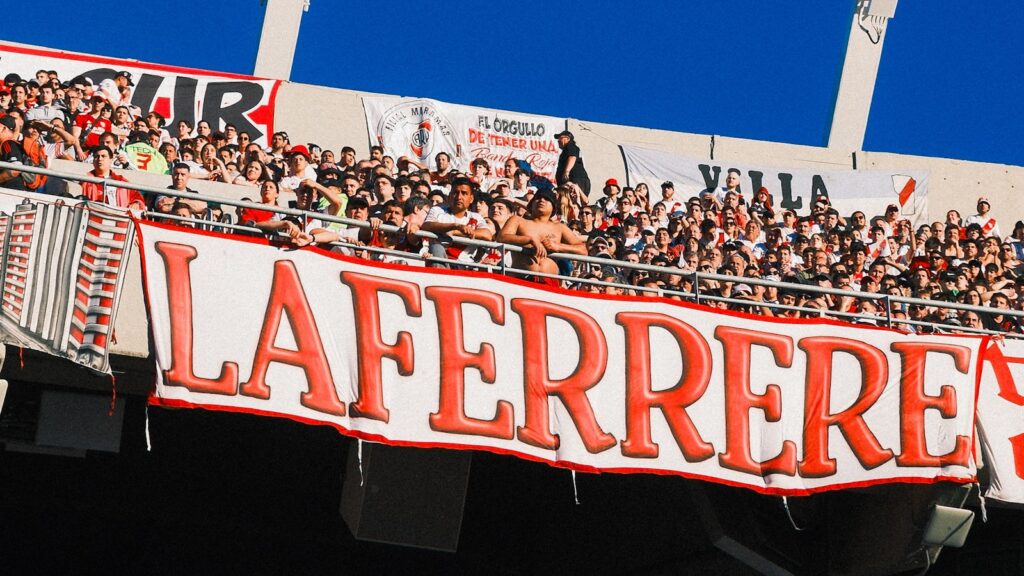 Soccer fans cheering with a banner in a packed stadium during the World Cup